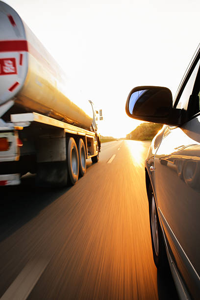 a speeding oil truck on a highway at dusk in shenzhen, china.